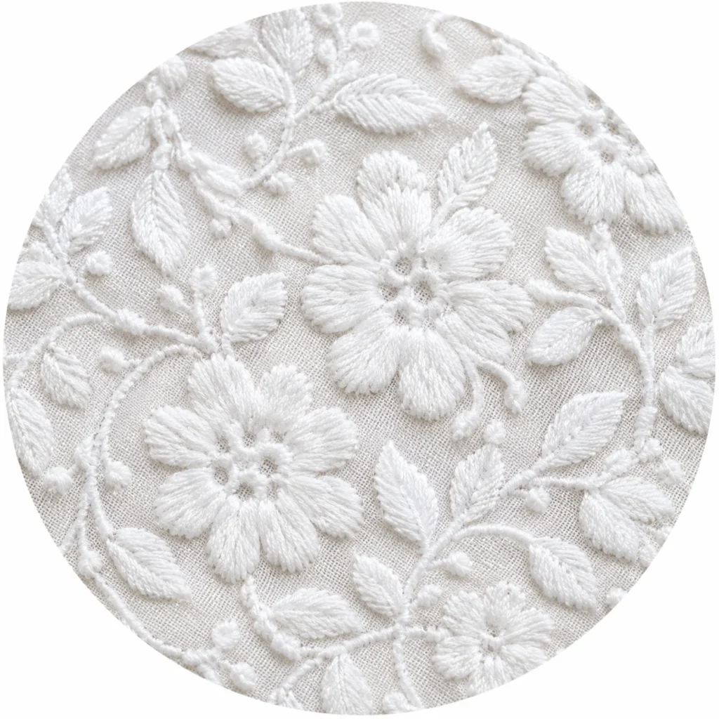 Close-up of white chikankari embroidered fabric texture used in women's kurtis.